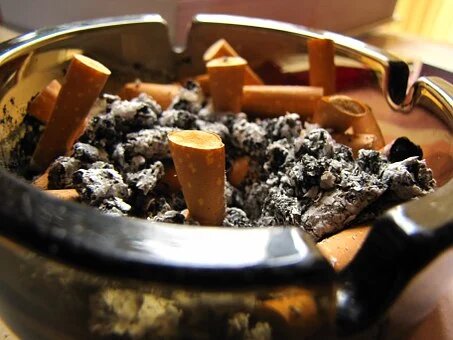 god addiction: ashtray, full of cigarettes.
