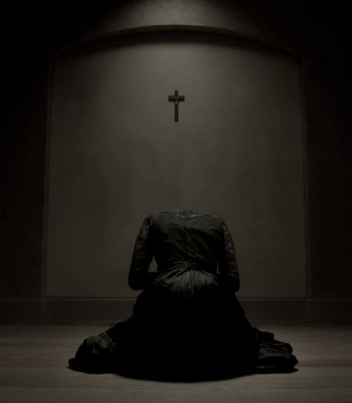 The Truth About Religious Patriarchy and Women's Abuse - Headless believer woman on knees before cross.